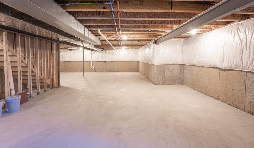 a basement with a concrete floor being waterproofed